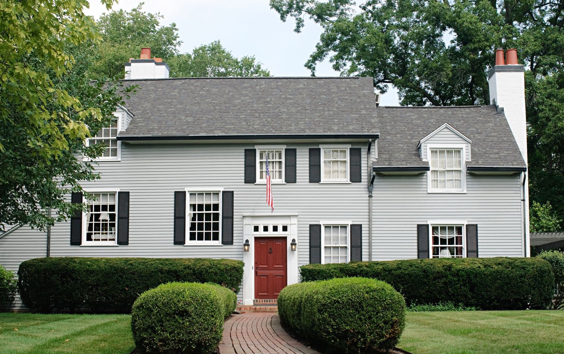Modern house with red door. Fresh roof and siding installation.